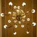 Dal soffitto, anchesso arricchito da fitte fantasie floreali, cadono infine cinque lampadari a bracci in ottone e vetro
